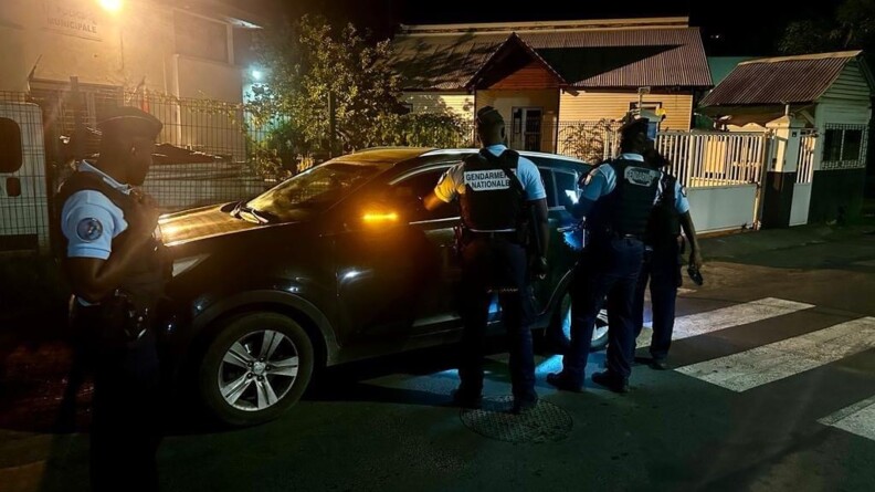 Dans la rue et de nuit, quatre gendarmes départementaux de Mayotte, contrôlent un véhicule.