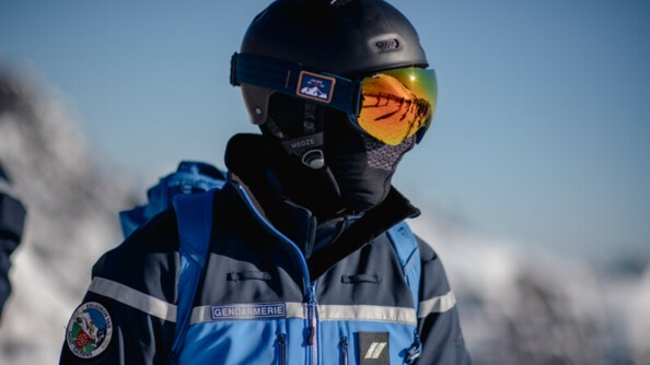 Un gendarme mobile équipé d'un masque de ski dans lequel se reflète les pistes de ski.