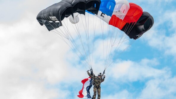 Léocadie Ollivier de Pury en descente de parachute avec le drapeau de la France accroché au dos.