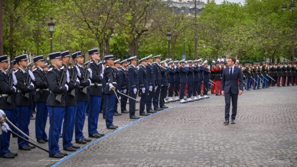 Le président de la République effectue la revue des troupes militaires qui sont alignées devant lui.