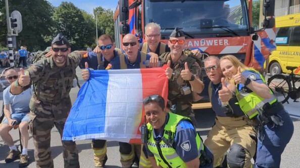 Des policières et des pompiers néerlandais venus encourager les participants posent avec les gendarmes et le drapeau français.