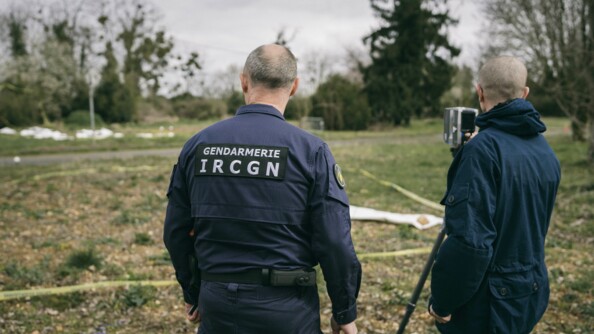 Deux gendarmes de l'IRCGN de dos avec un appareil laser qui permet de faire une cartographie 3D du lieu.
