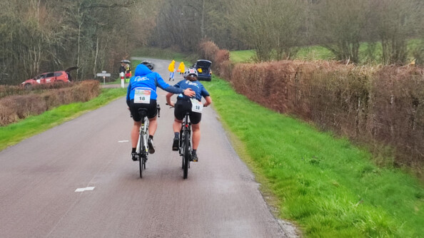 Deux cyclistes de l'équipe de la gendarmerie nationale roulent ensemble sur une route lors de la course du coeur 2023.