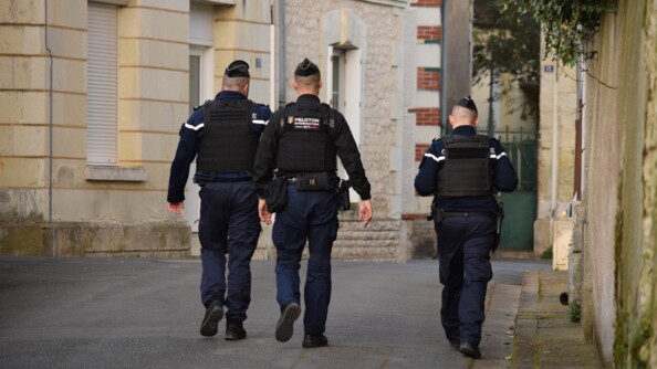 Deux gendarmes départementux et un gendarme mobile de dos dans une rue en patrouille pédestre