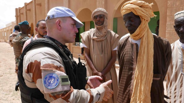Un gendarme en mission pour l'Organisation des Nations Unies échange avec des habitants à Tombouctou.