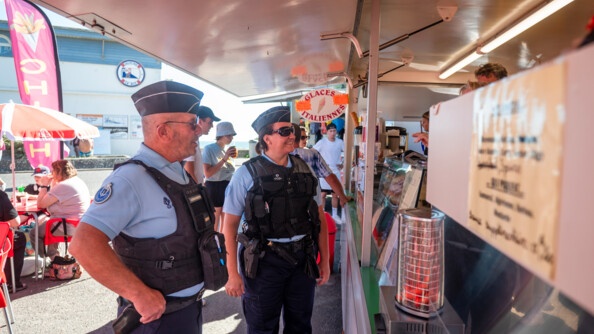 Deux gendarmes échangent avec un commerçant, marchad de glaces italiennes, à Damgan.