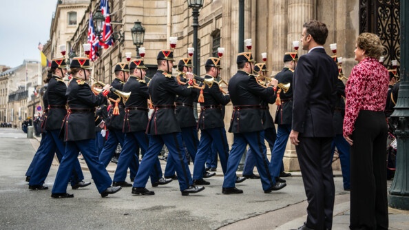 Gardes républicains rentrant dans la cour de l'Élysée devant le Président de la République et l'ambassadrice du Royaume-Uni.