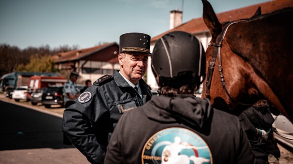 Le général de corps d’armée Bruno Arviset, Directeur des personnels militaires de la gendarmerie nationale (DPMGN), au centre, de face, échange avec une participante du stage Cent'Or, de dos, tenant son cheval, à droite.