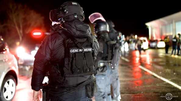 Gendarmes d'unité d'intervention de dos, de nuit.