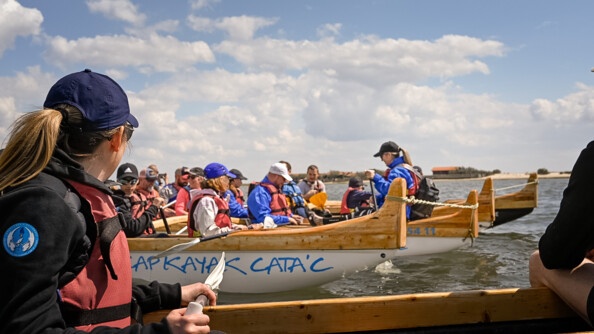 Les participants sont sur l'océan à bord de pirogue, paguet à la main.