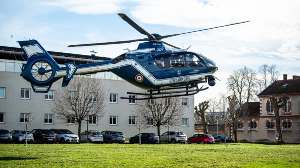 Hélicoptère EC 135 de la gendarmerie en vol au-dessus d'une pelouse