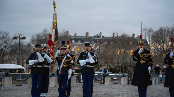 Sur le parvis de l'Arc de Triomphe, la garde au drapeau composée de six gendarmes en grande tenue. A ses côtés, un garde républicain au garde à vous, sabre en main.