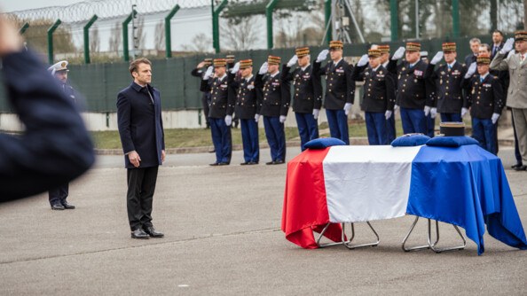 Le président de la République, Emmanuel Macron, devant le cercueil du major Arnaud Blanc, recouvert du drapeau français.