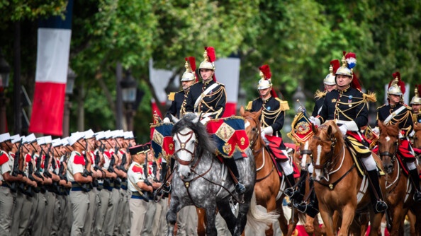 Les premiers chevaux et cavaliers de la musique de la Garde républicaine passent devant un détachement de la Légion étrangère