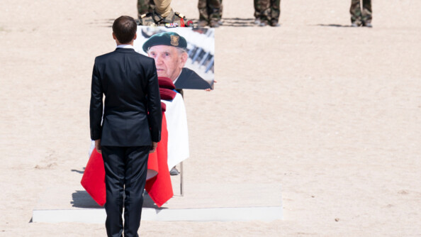 Le président de la République de dos face au cercueil de Léon Gautier, recouvert du drapeau français, sur lequel est posé sa photo.