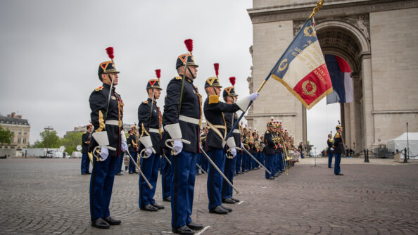 La Garde au drapeau de profil devant l'Arc de Triomphe avec la musique de la Garde au second plan.