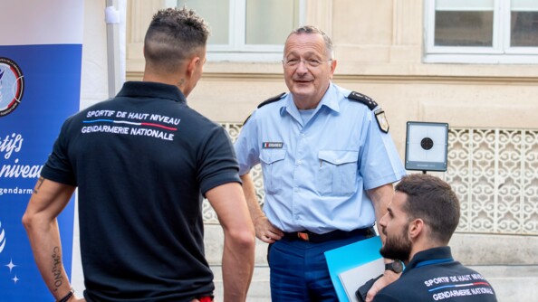 Le directeur général de la gendarmerie nationale, le général d'armée Christian Rodriguez, échange avec deux sportifs de haut niveau de la Défense - gendarmerie.