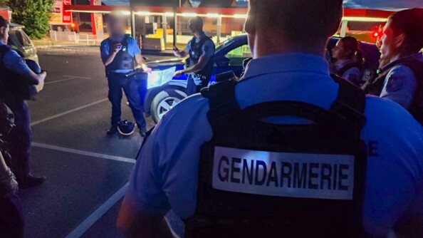 Les gendarmes sont réunis en cercle autour de leur chef sur un parking d'une station service.