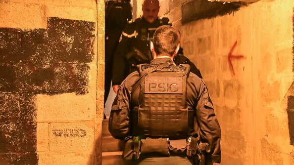 Gendarme d'un Peloton de surveillance et d'intervention de gendarmerie (PSIG) de dos dans une cave d'immeuble.