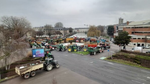 Vue de haut de plusieurs dizaine de tracteurs dans les rues d'une ville.