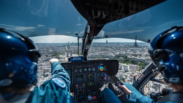 Vue de Paris à partir d'un cockpit d'hélicoptère de la gendarmerie, avec deux personnels naviquant à bord