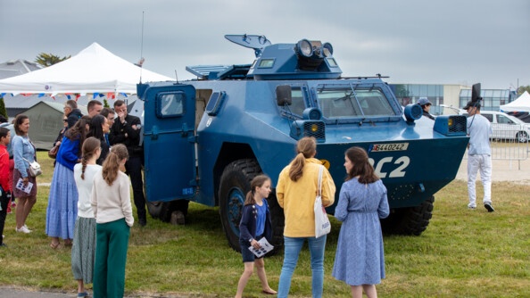 Un véhicule blindé de la gendarmerie avec plusieurs visiteurs autour.