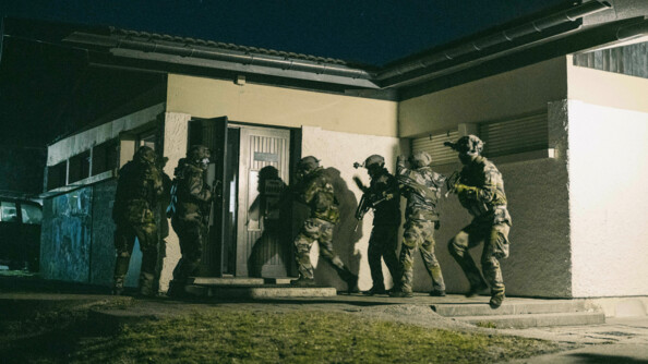 Sept militaires s'apprêtent à prendre d'assaut un bâtiment de nuit