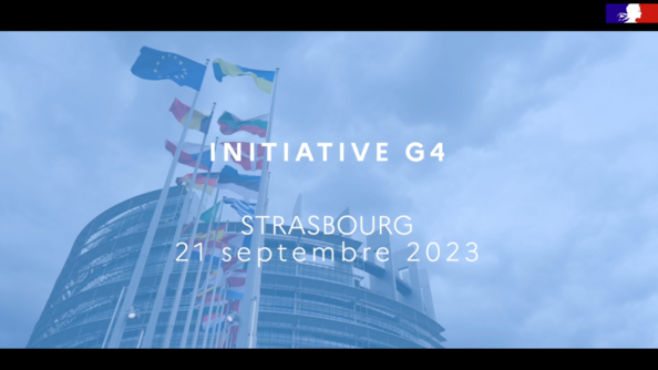 Devant le parlement européen vu en contre-plongée, avec les drapeaux flottant au vent, le texte en blanc "Initiative G4 Strasbourg 21 septembre 2023"