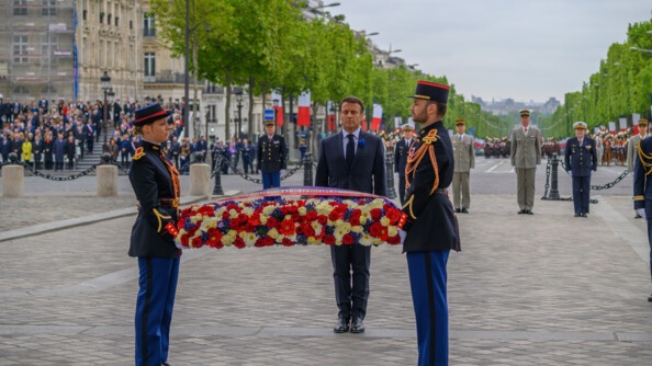 Le président de la République fait face à la tombe du soldat inconnu. Il s'apprete à déposer une gerbe tenue par deux gardes républicains.