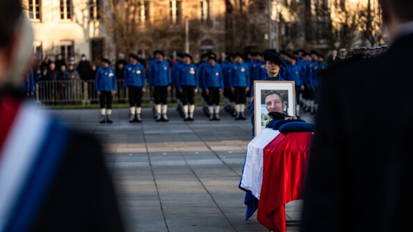 Le cercueil avec un portrait du gendarme tenu par une de ses camarades du PGHM