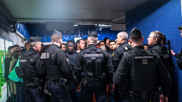 Gendarmes régulant les flux de passagers en attente dans une station de métro.