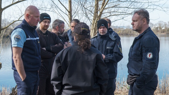 Avant la mise à l'eau, a lieu un échange au bord du plan d'eau entre des gendarmes français et des personnels des unités Suisses et Allemandes.