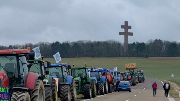Une file de tracteurs sur la route devant la fameuse croix lorraine près de Colombey-les-deux-églises.