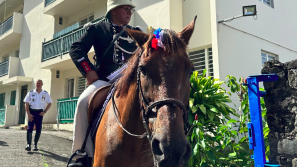 Un acteur en uniforme de l'époque monte à cheval dans la cour de la caserne.