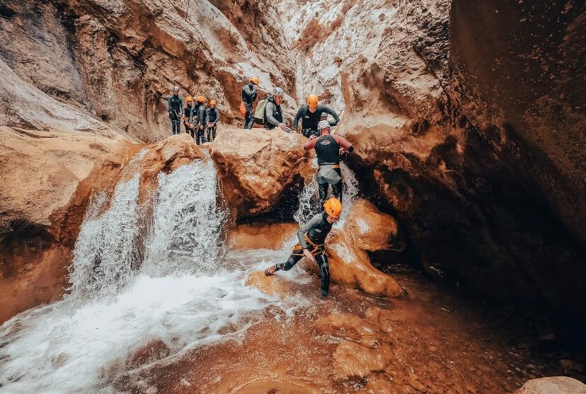 Aidés de moniteurs, deux gendarmes franchissent une cascade tandis que d'autres attendent leur tour plus haut.