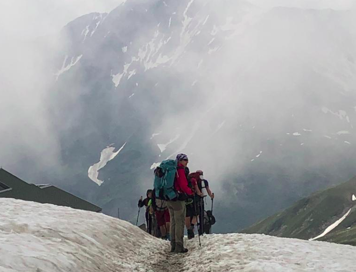 Les randonneurs marchant dans la neige au milieu du brouillard.