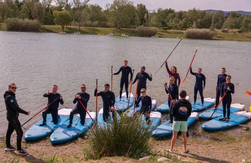 Les gendarmes participants au stage Aquaphénix sont debout ou à genou sur leurs paddles.