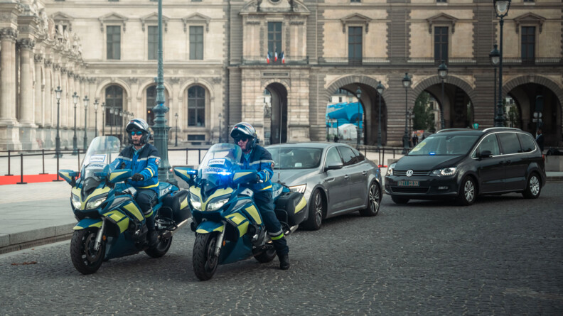 Deux motocyclistes escortant des véhicules.