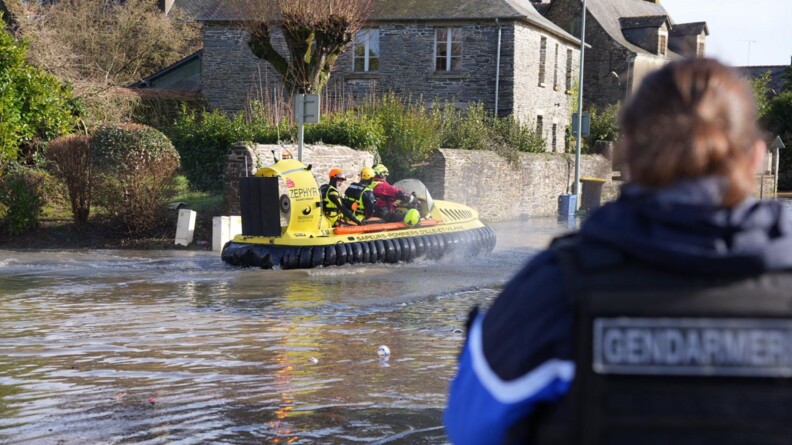 Gendarme de dos devant un aéroglisseur.