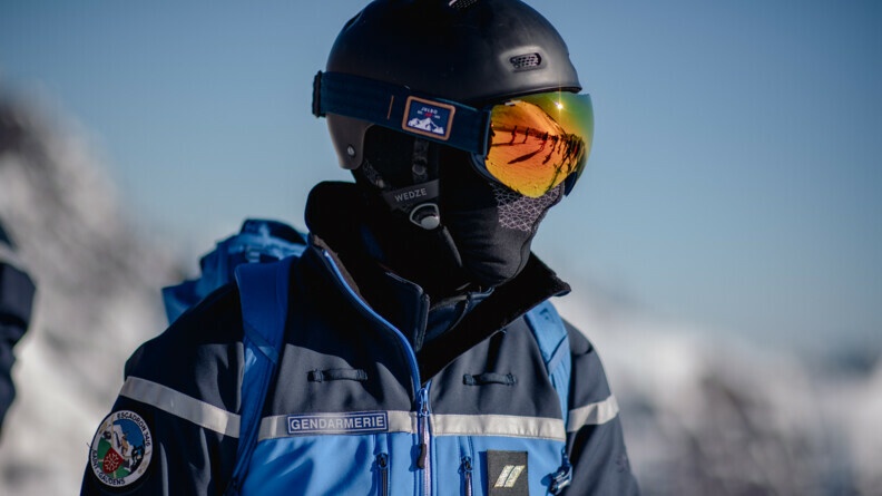 Agrandir l'image Un gendarme mobile équipé d'un masque de ski dans lequel se reflète les pistes de ski.