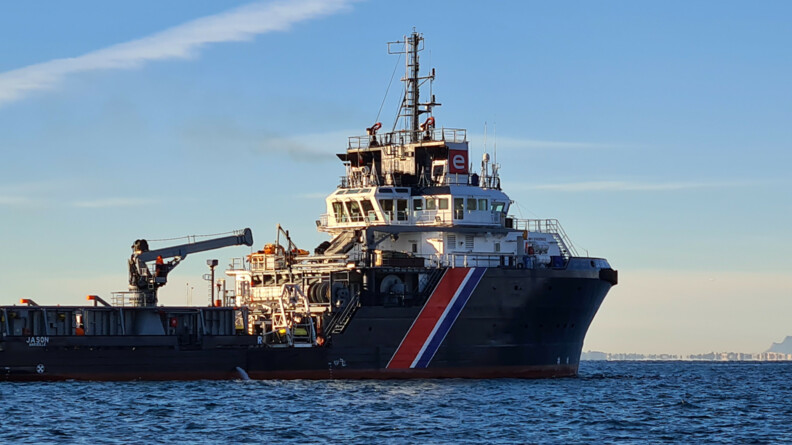 Agrandir l'image Vue trois quart arrière droite du Jason, remorqueur de haute mer sur les flots; au fond à droite, une vedette de la gendarmerie maritime