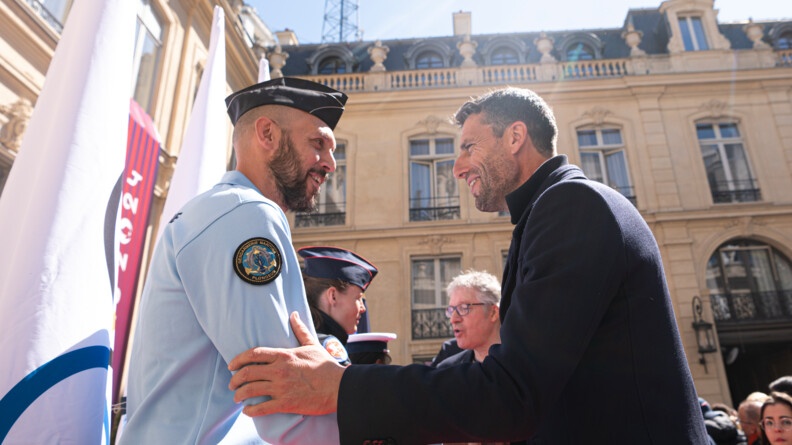 Photo de Hugues Duboscq en tenue de gendarme et de Tony Estanguet&nbsp;qui se serrent la main.