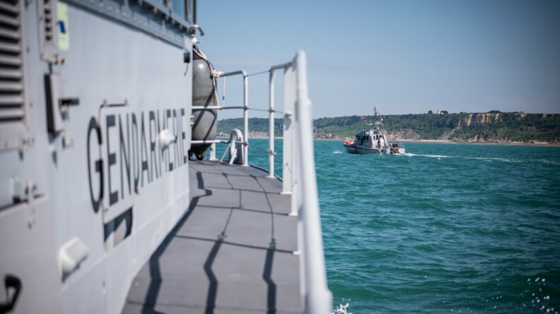 Agrandir l'image En mer au large des côtes qui se dessine en fond, deux bateaux de la gendarmerie naviguent.