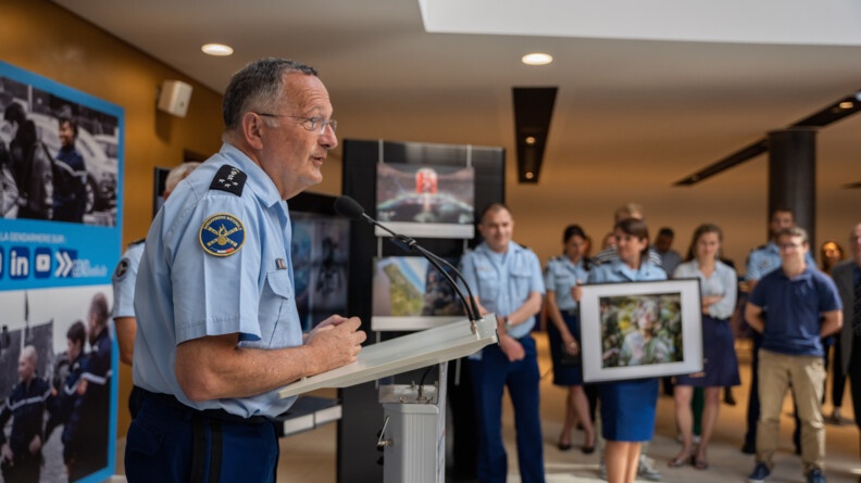 Le g&eacute;n&eacute;ral Christian Rodriguez fait un discours dans la salle d'exposition. Il pr&eacute;sente en m&ecirc;me temps la photo qu'il a choisie.