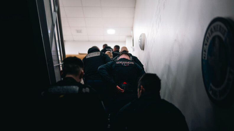 Les gendarmes en groupe, remontent un escalier. Ils se préparent à partir.