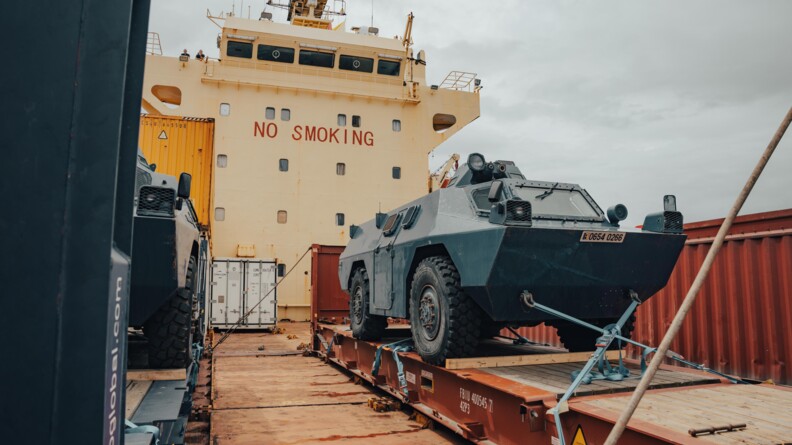 Un VBRG bleu descend la pente d'un porte- container