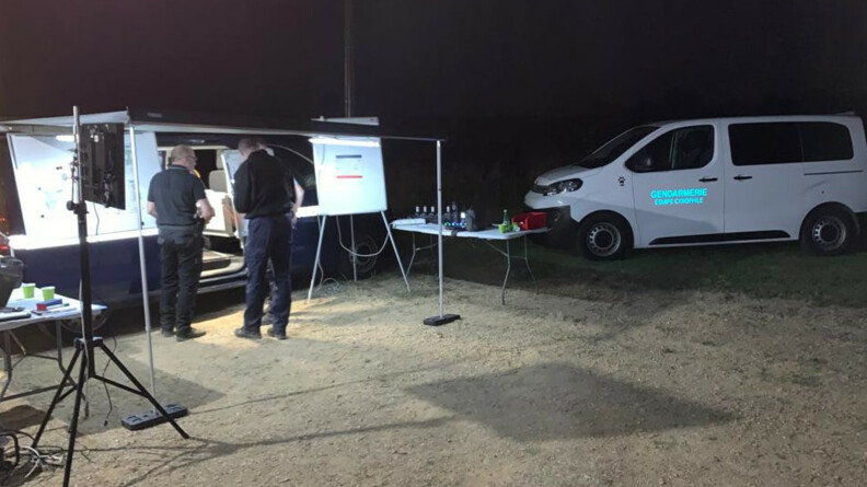 Poste de commandement gendarmerie de nuit. Sur la gauche un v&eacute;hicule commandement avec un auvent, &agrave; droite un v&eacute;hicule blanc sigl&eacute; enbleu ciel "Gendarmerie &eacute;quipe cynophile"