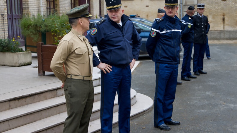 un officier des marines et un géénral de gendarmerie échangent un regard. à droite un autre général