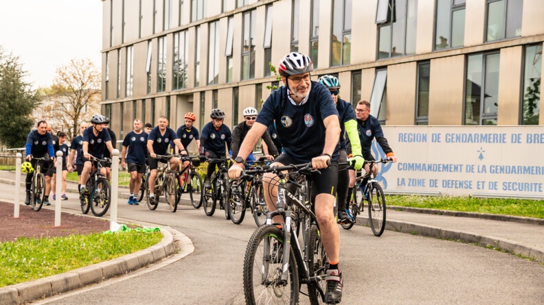 Départ à vélo d'un groupe de gendarmes devant le siège de la Région de gendarmerie de Bretagne.