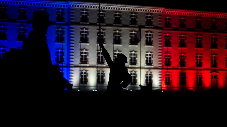 Major tambour dirige la musique - personnes sont en obres chisnoises devant l'atat-major illuminé de bleu blanc rouge